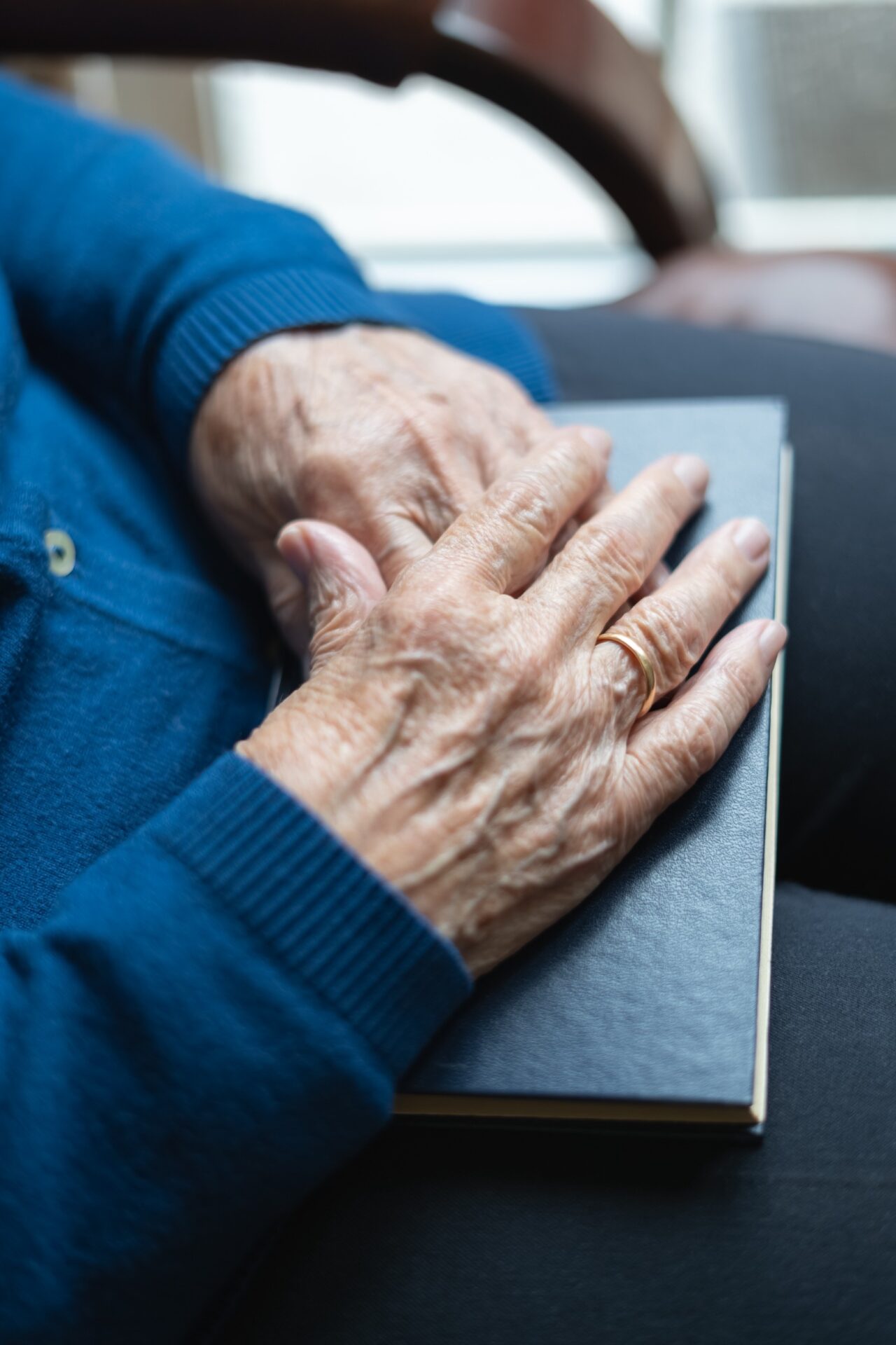 elderly hands on top of a book