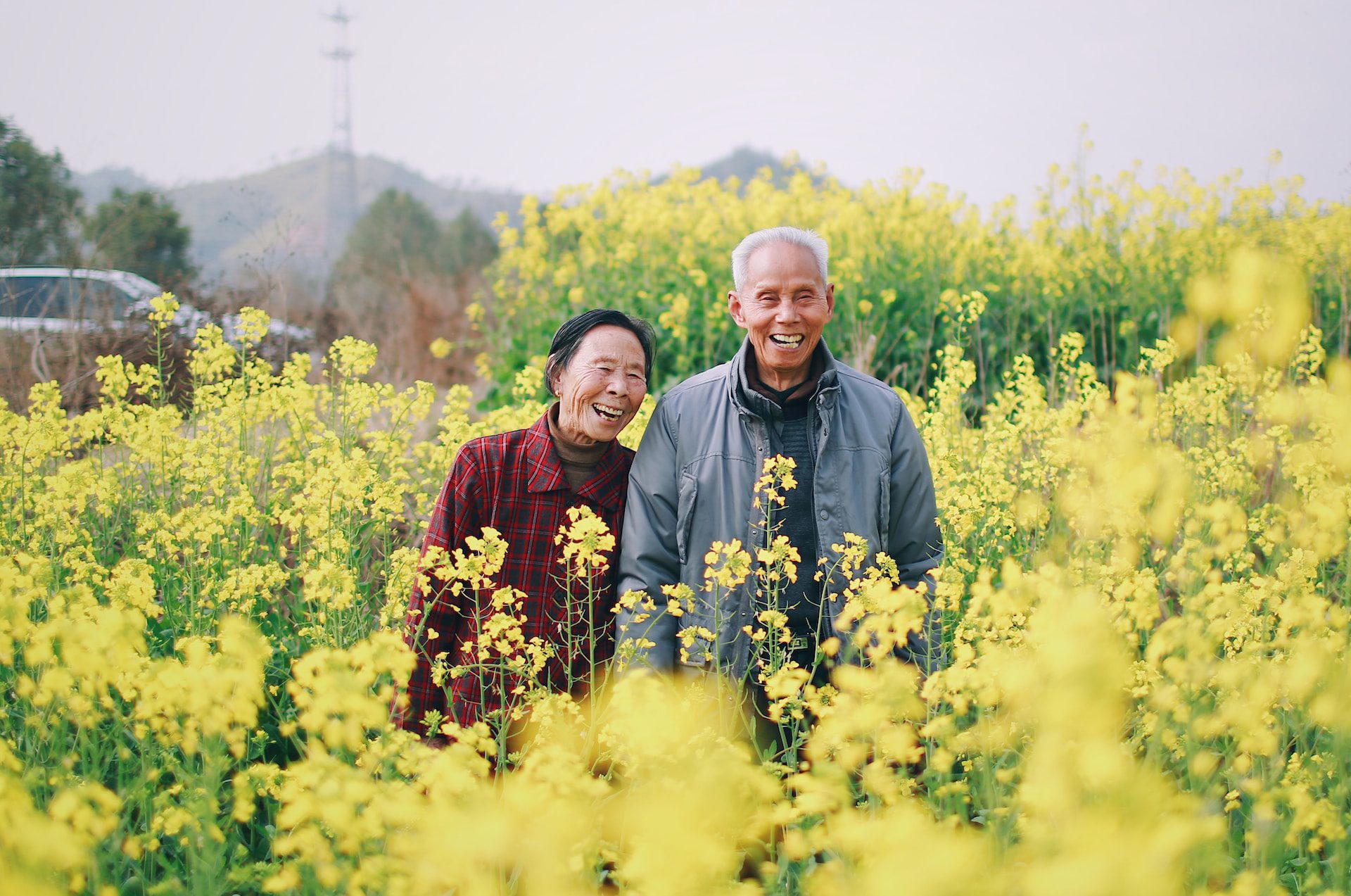 man and women standing in the middle of flowers